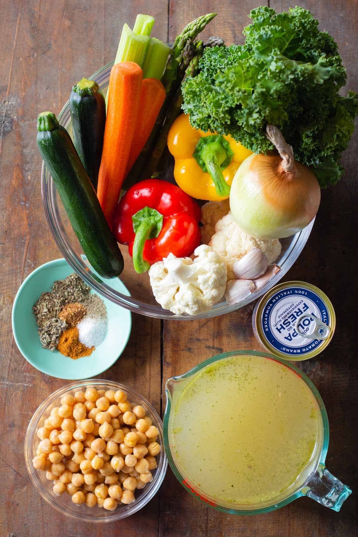 Ingredients for Vegetable Soup in bowls on a wooden table