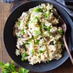 Mushroom and Pea Risotto in a grey bowl on a wooden table