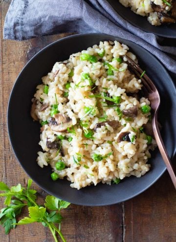 Mushroom and Pea Risotto in a grey bowl on a wooden table