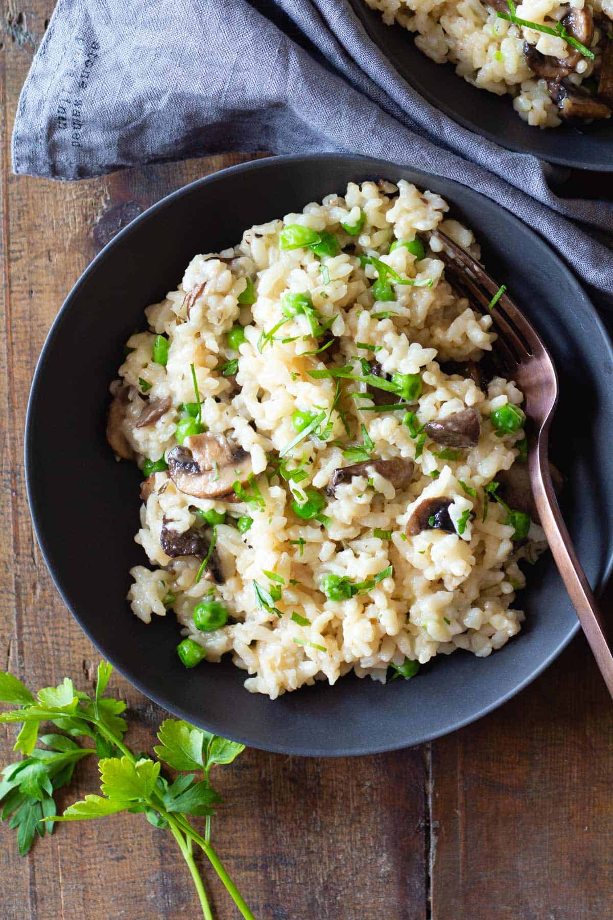 Mushroom and Pea Risotto in a grey bowl on a wooden table