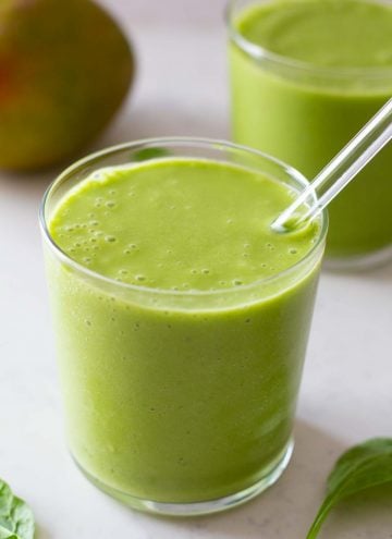 Spinach Mango Smoothie in a glass with glass straw