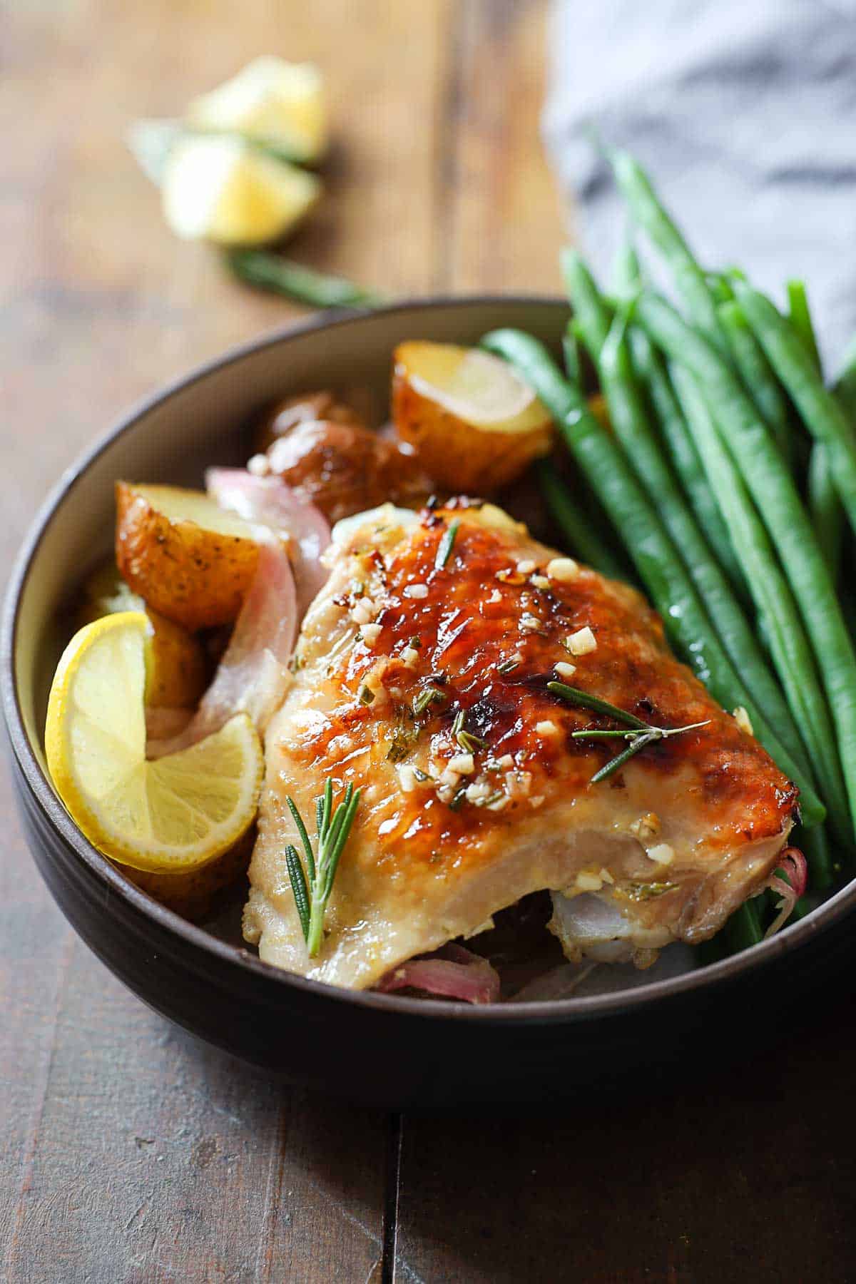Rosemary Lemon Chicken with green beans and baby potatoes in a bowl.