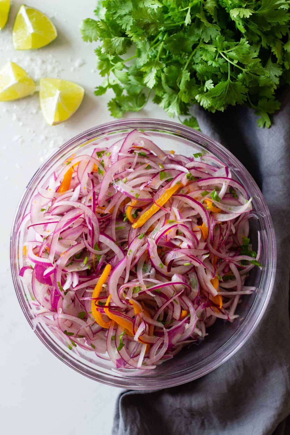 sliced red onion, aji amarillo pepper and cilantro (a.k.a. as salsa criolla) in a mixing bowl.