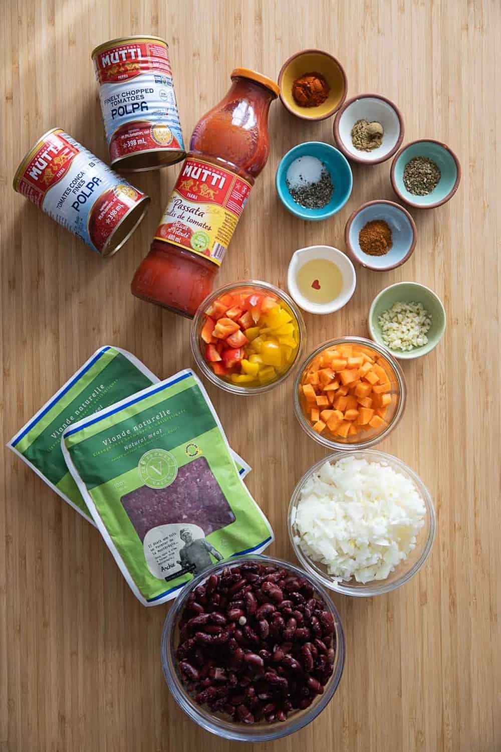 Ingredients for Instant Pot Chili. Canned chopped tomatoes, spices, chopped onion, chopped vegetables, ground beef, kidney beans.