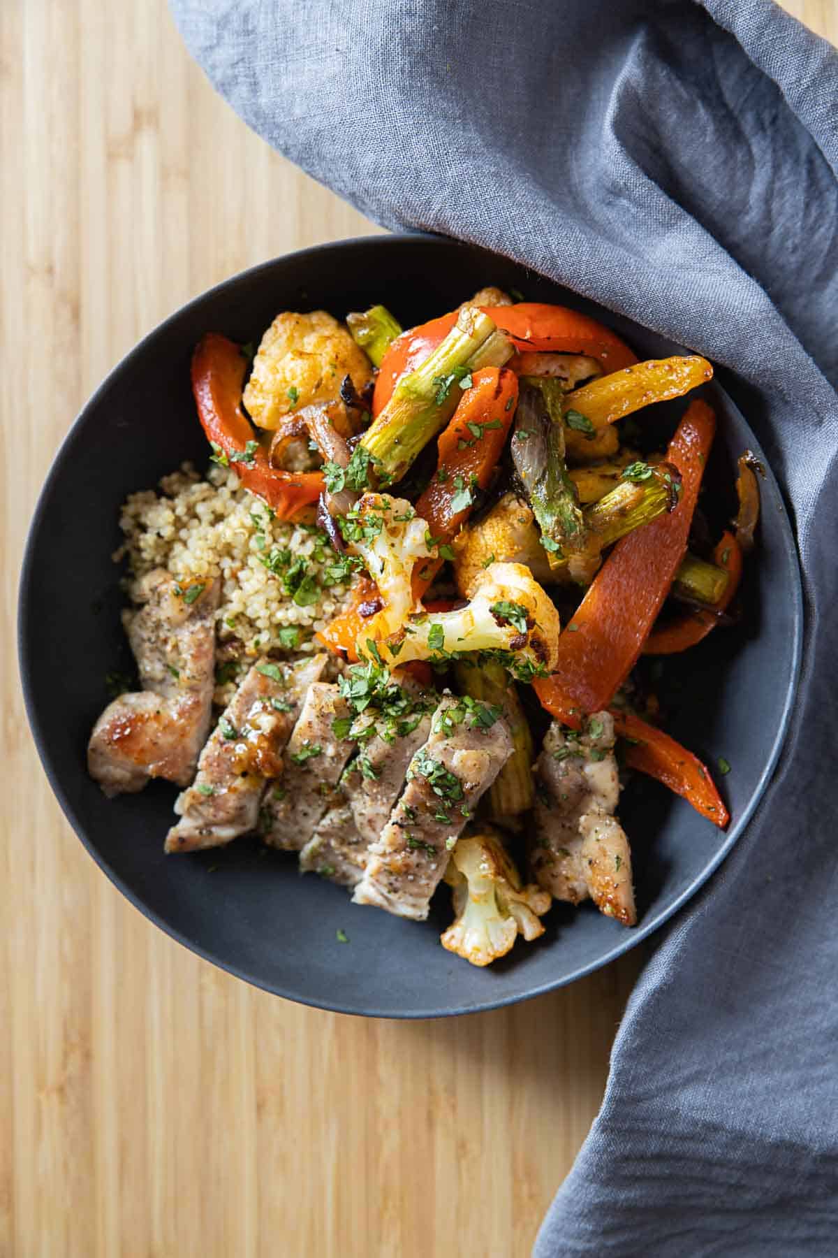 Roasted vegetables, chicken, and quinoa in a grey bowl.