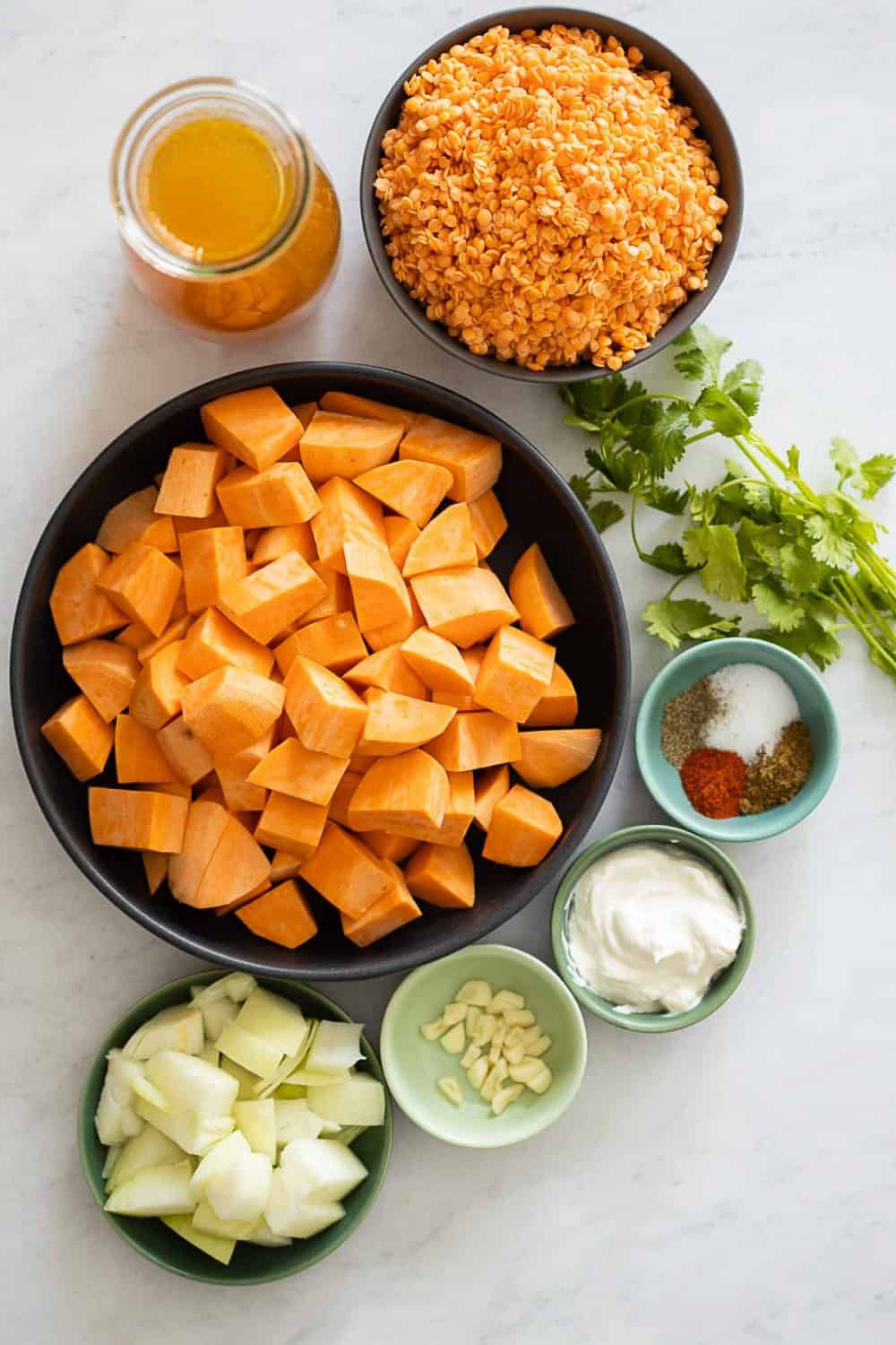 Ingredients used for Red Lentil Sweet Potato Soup displayed on a kitchen counter.