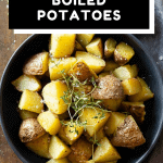 Cooked cut up red potatoes in a grey bowl garnished with fresh thyme with text overlay for Pinterest.