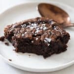 Closeup of a brownie piece on a white plate to show texture on the inside. paleo brownies recipe