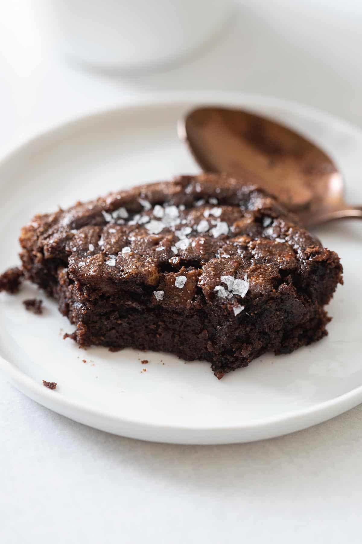 Closeup of a brownie piece on a white plate to show texture on the inside. paleo brownies recipe