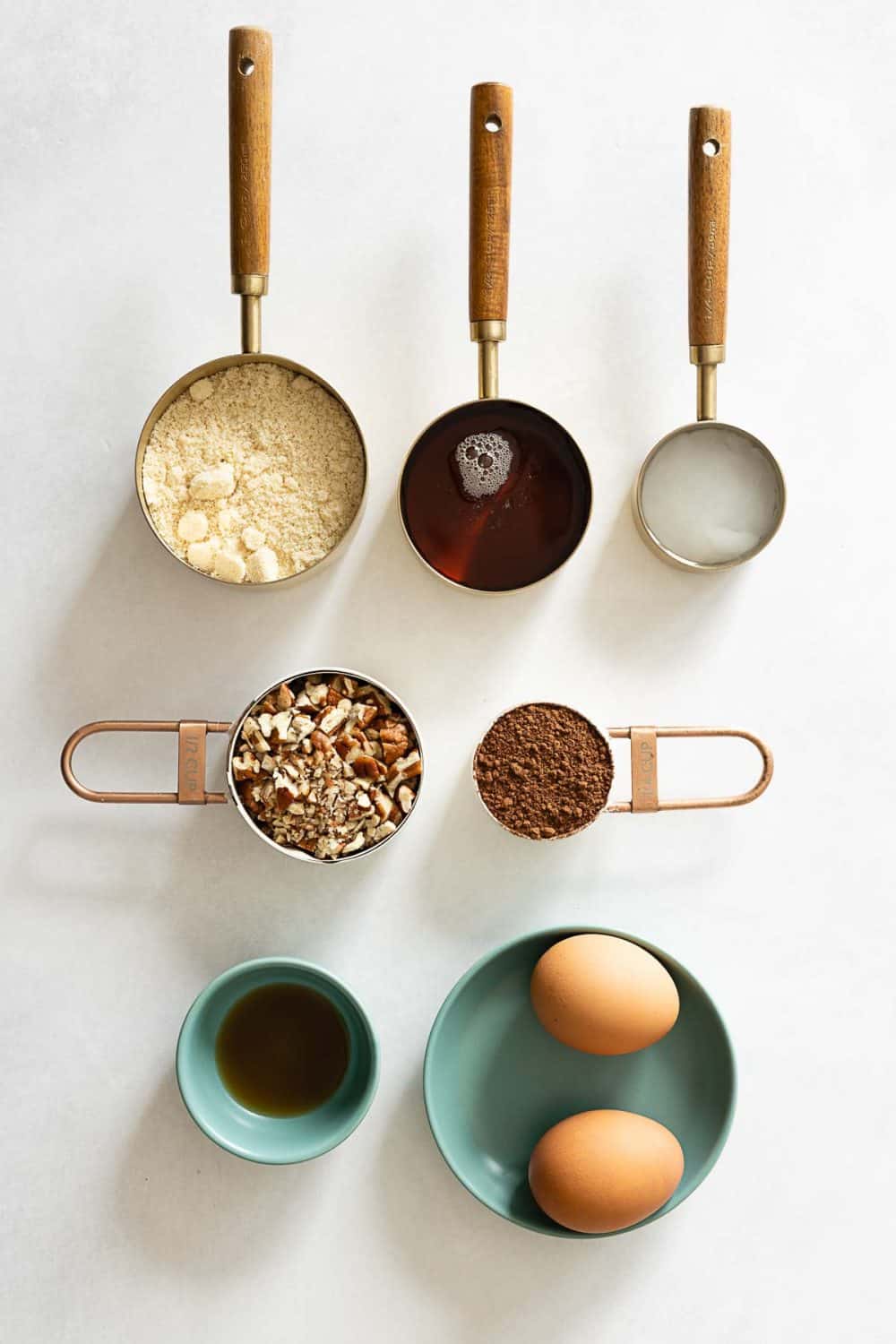 7 Brownie Ingredients in measuring cups on a kitchen counter.