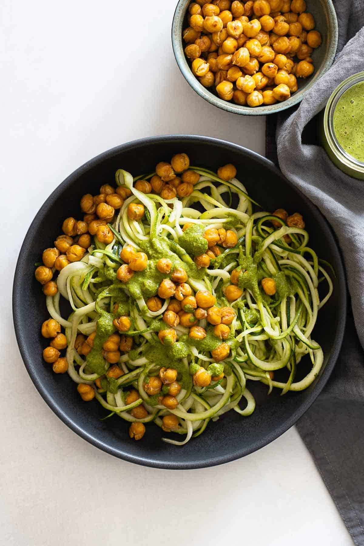 Zucchini noodles topped with crispy chickpeas and herb sauce.