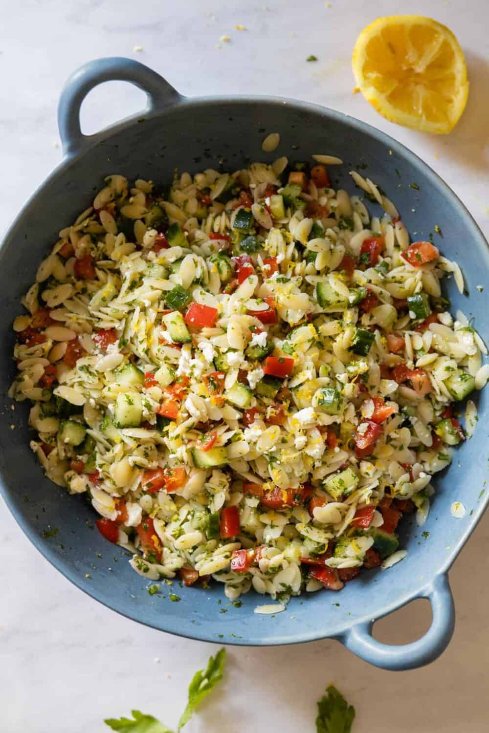 Lemon Orzo Salad in a blue salad bowl view from the top down.