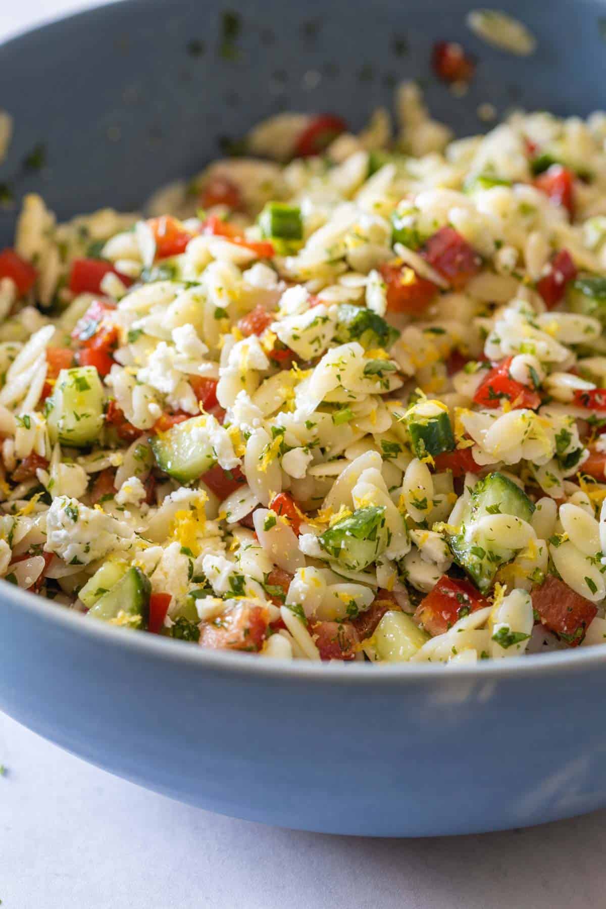 Mixed Lemon Orzo Salad in a blue salad bowl.