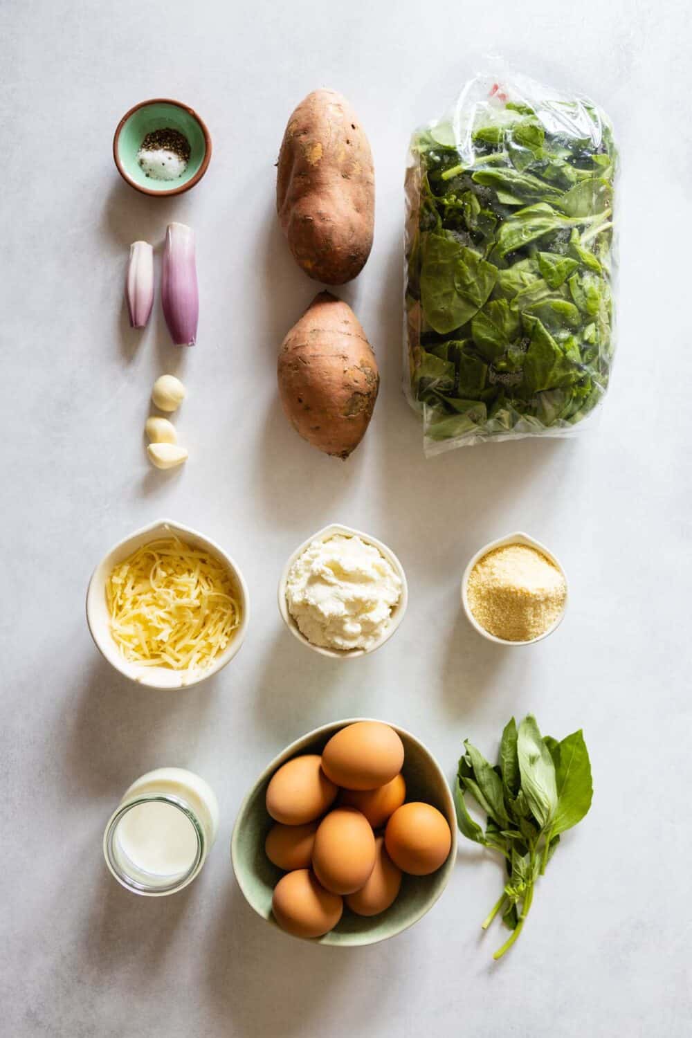 All ingredients for the crustless spinach quiche laid out on a kitchen counter.