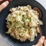 Coconut Rice in a blue bowl held in hands.