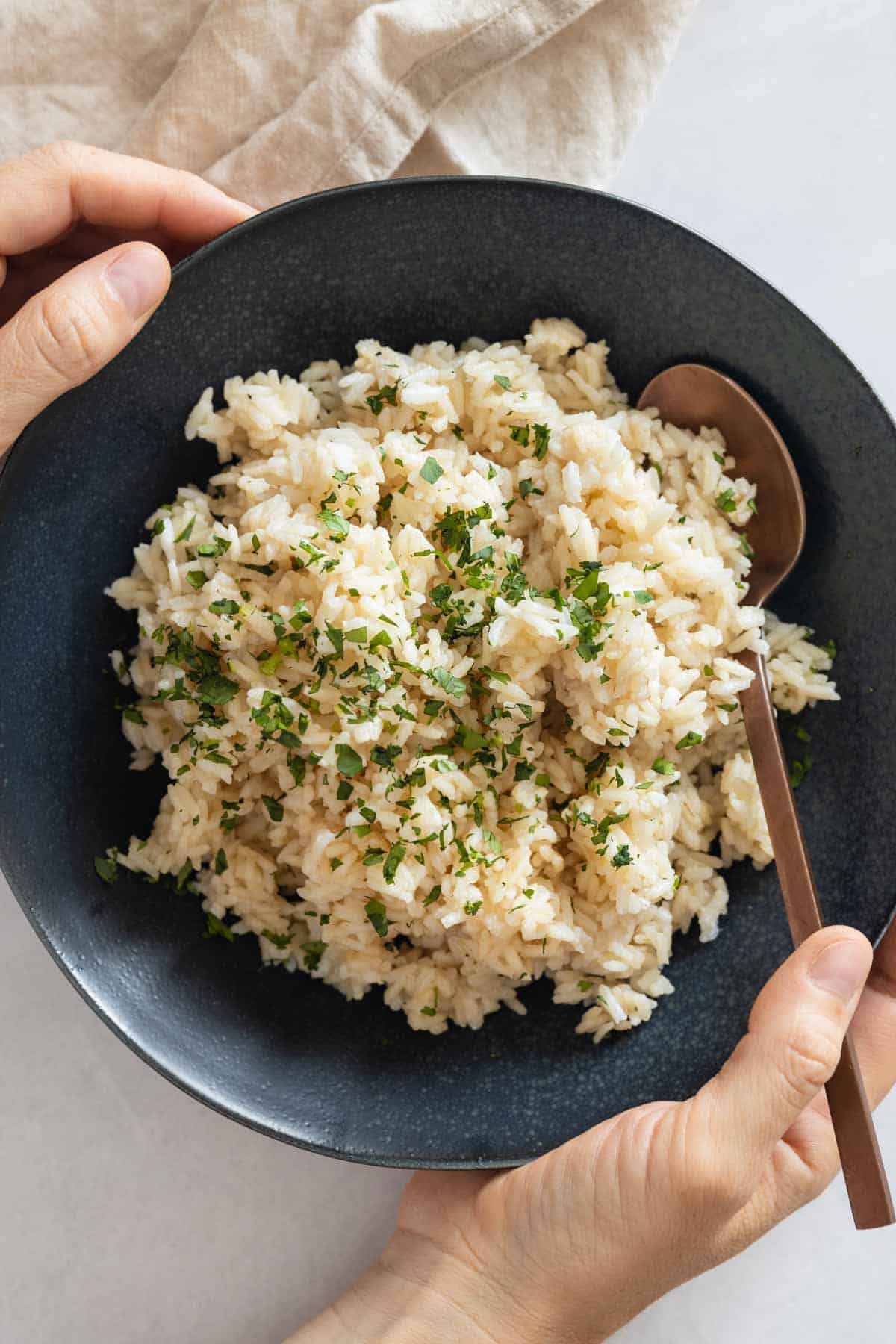 Coconut Rice in a blue bowl held in hands.