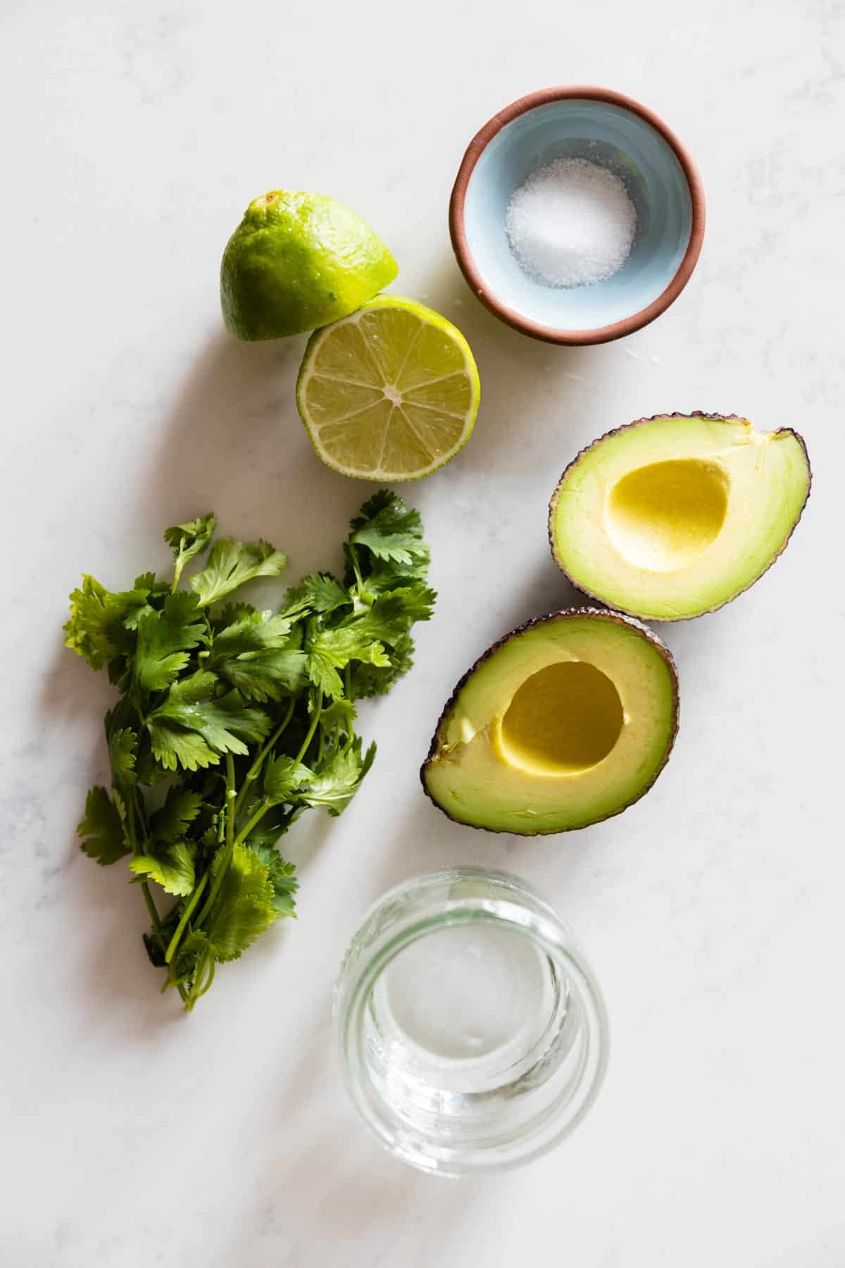 Ingredients for cilantro lime avocado dressing laid out on a kitchen counter.