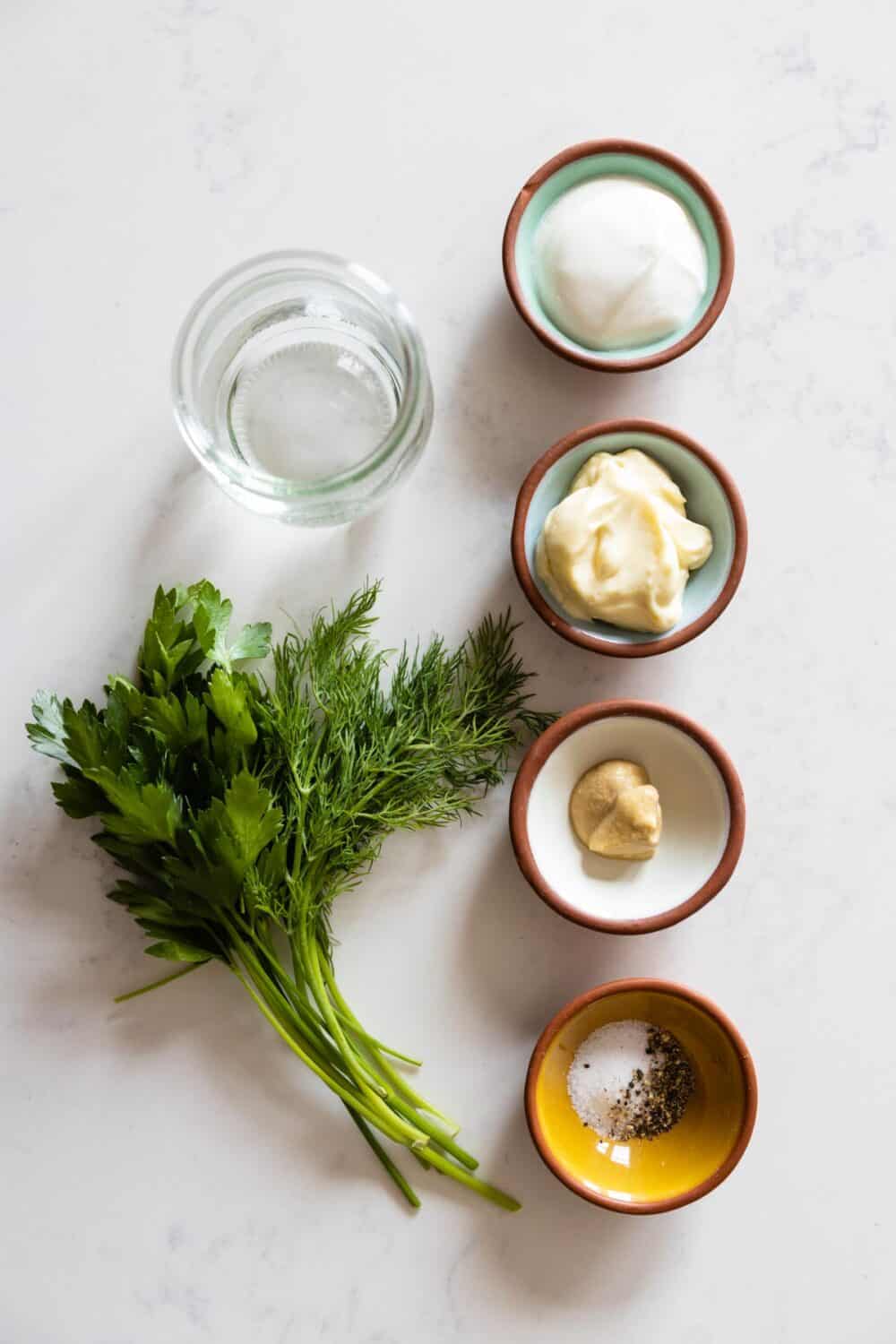 Ingredients for Greek Yogurt Herb Dressing laid out on a kitchen counter.