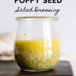 Glass jar with yellow salad dressing with title reading: Lemon Poppy Seed Salad Dressing.