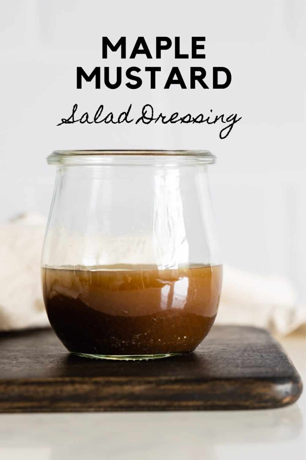 Glass jar with brown salad dressing with title reading: Maple Mustard Salad Dressing.