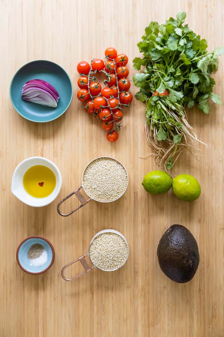 Ingredients for quinoa salad laid out on a kitchen counter.