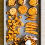 Baked sweet potatoes cut up into rounds, cubes, dice, and as a whole on a baking sheet.