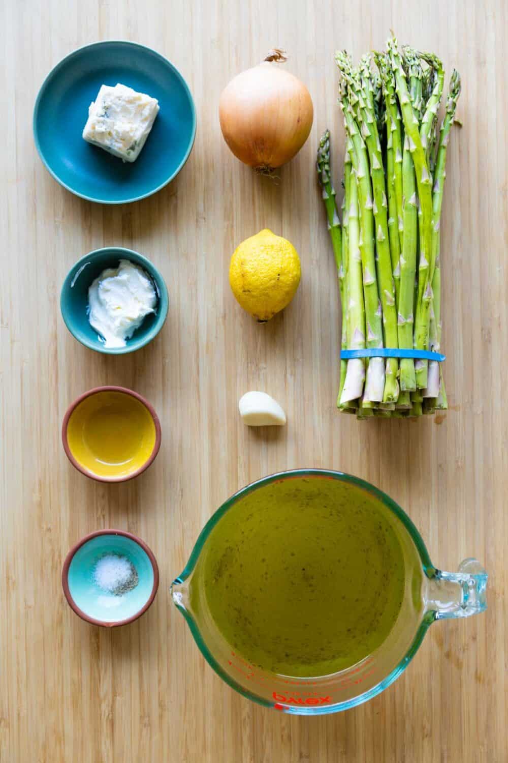 Ingredients for asparagus soup laid out on a kitchen counter.