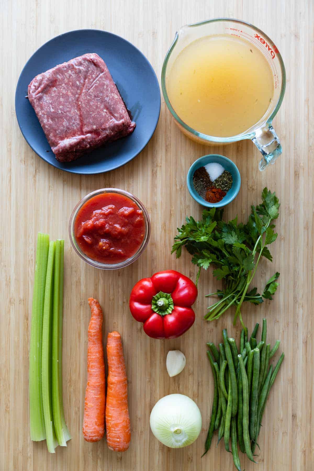 Ingredients for beef vegetable soup laid out on a kitchen counter.