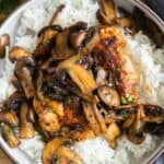A bowl with rice, chicken, and mushrooms.