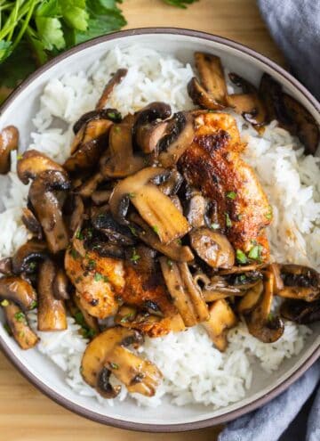 A bowl with rice, chicken, and mushrooms.