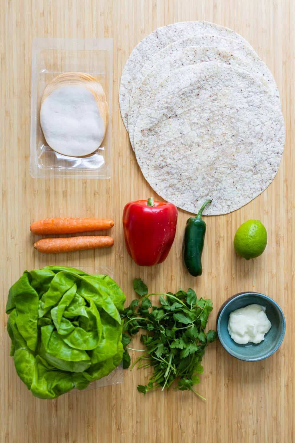 Ingredients for turkey wraps laid out on a kitchen counter.