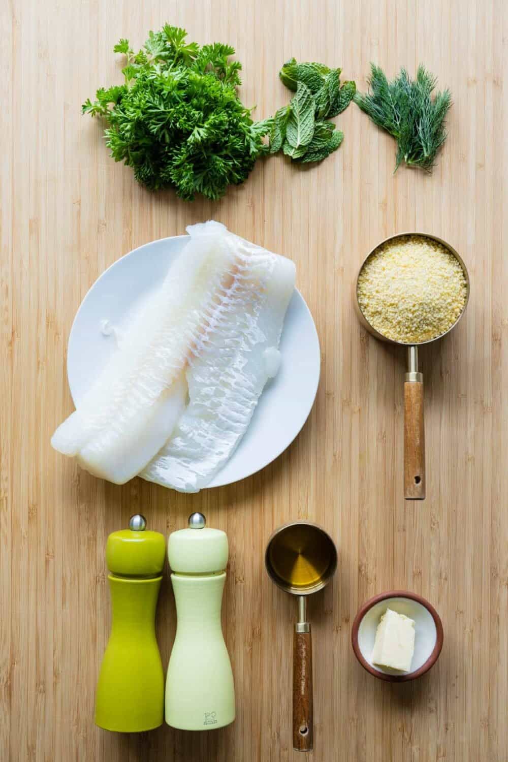 Ingredients for baked haddock with herb couscous laid out on a kitchen counter.