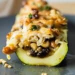 Cut-up stuffed zucchini boat on a gray plate.