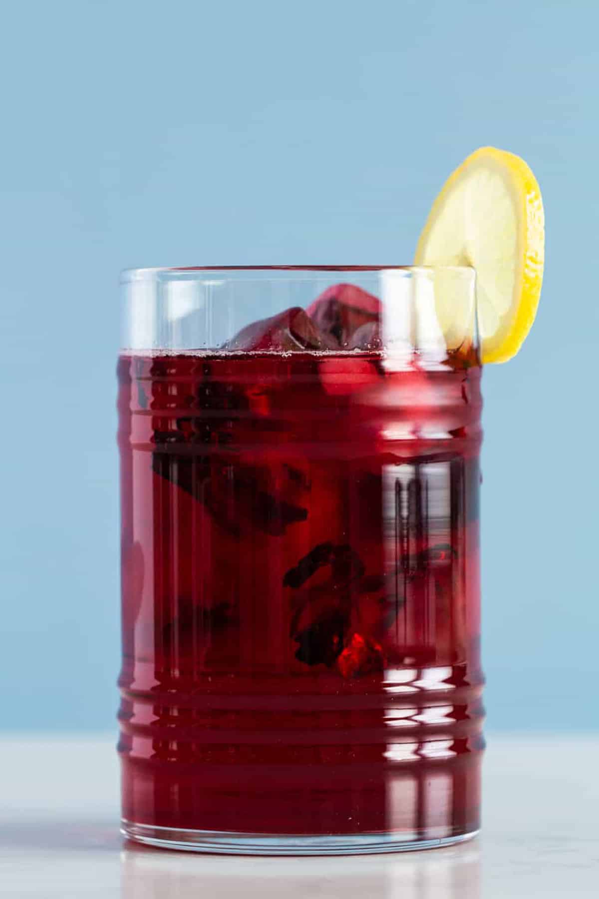 Dark red Agua de Jamaica in a glass.