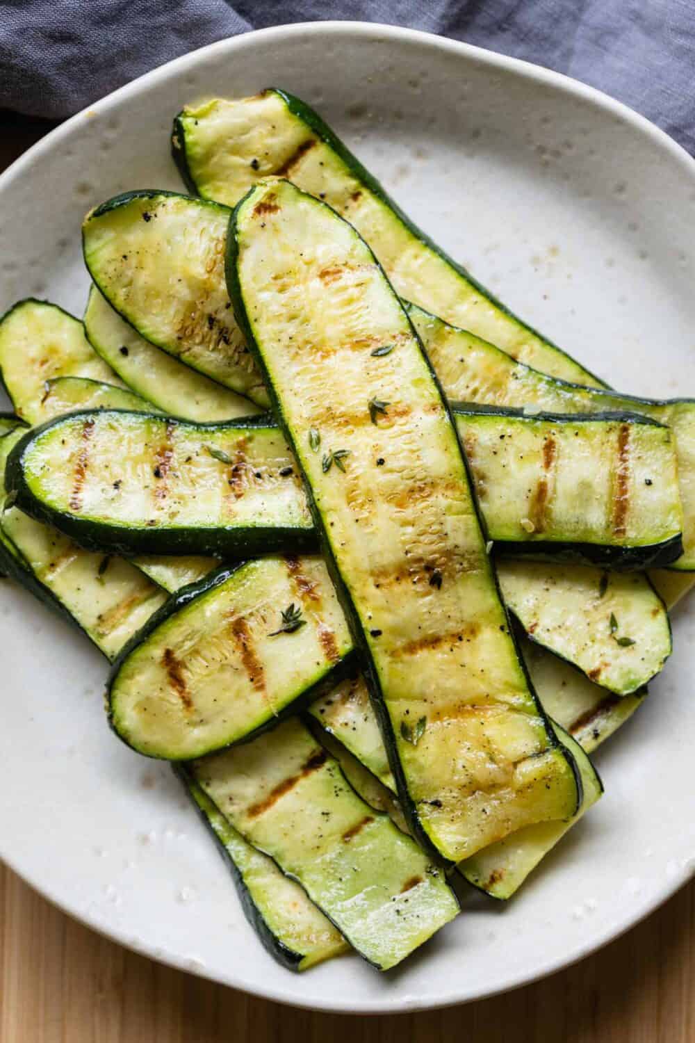 Thinly sliced grilled zucchini on a plate.