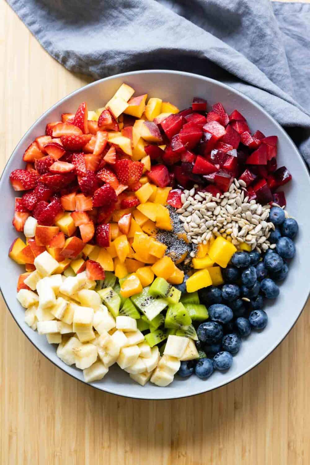 Unmixed fruit salad. Chopped up fruit in a bowl by sections.