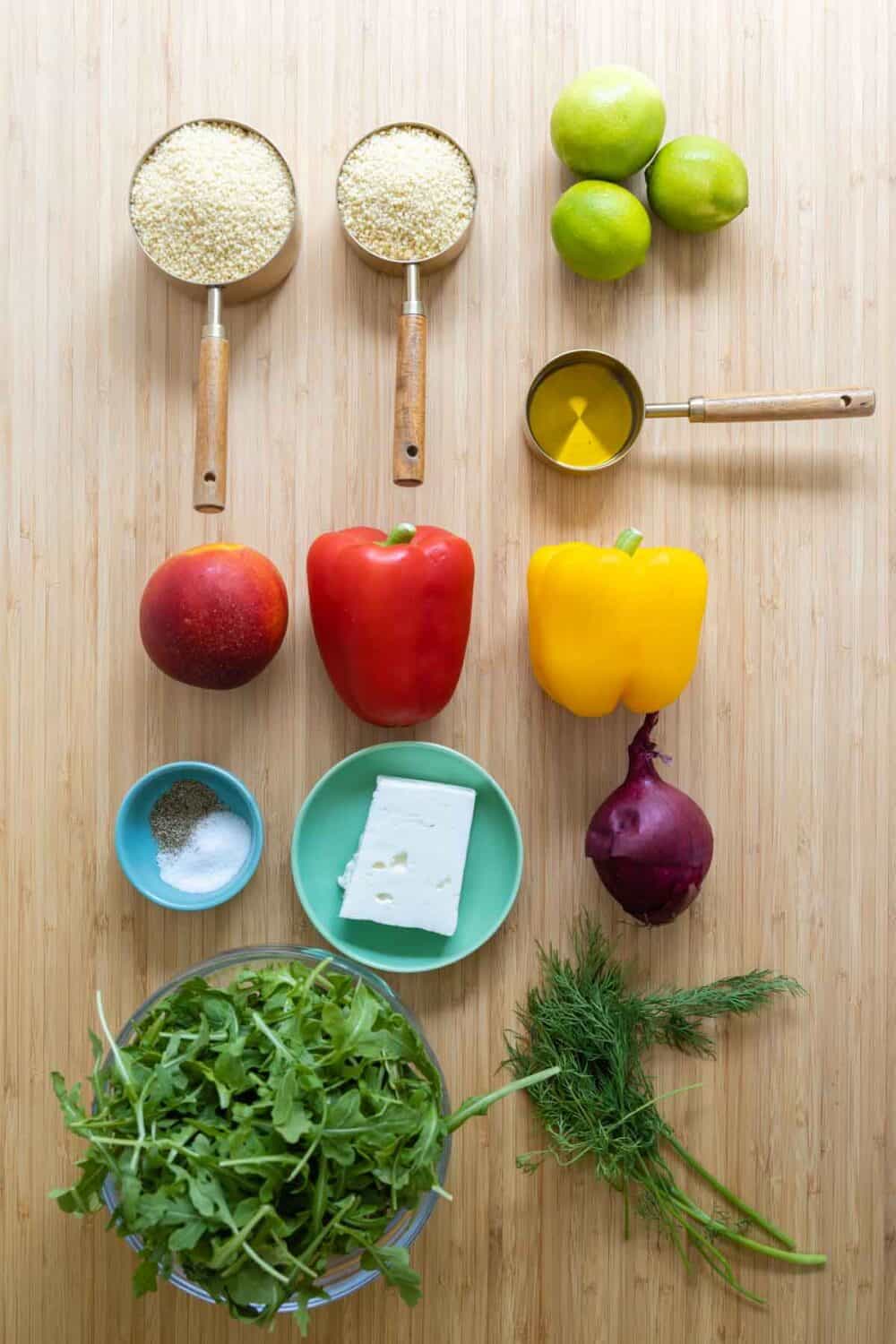 Ingredients for couscous salad laid out on a kitchen counter.