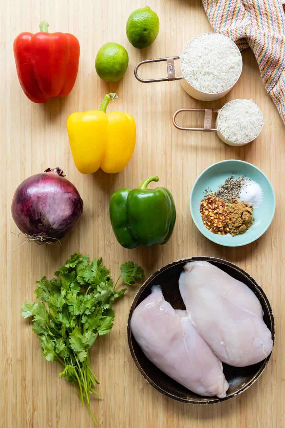 Ingredients for chicken fajitas meal prep bowls laid out on a kitchen counter.