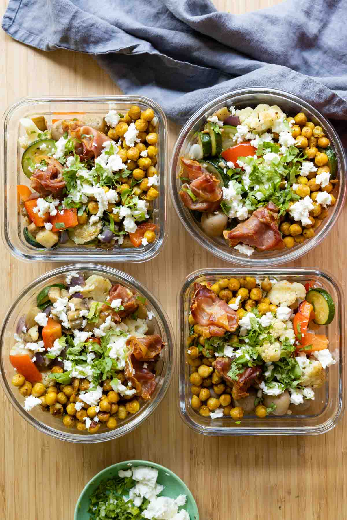Four meal prep containers filled with chickpeas and vegetables.