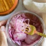 Closeup shot of texture of pickled shallots in a jar.