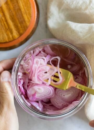 Closeup shot of texture of pickled shallots in a jar.