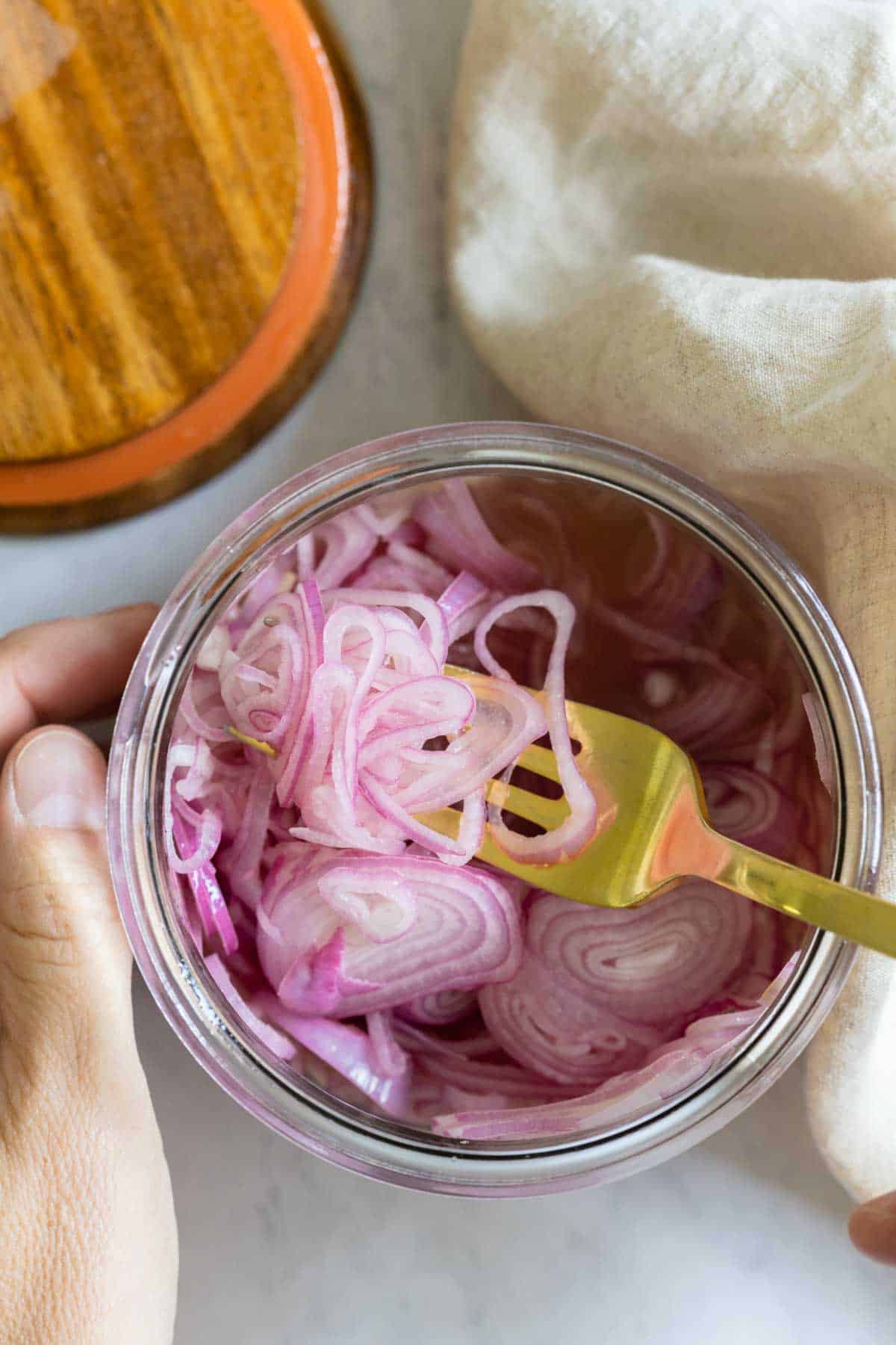 Closeup shot of texture of pickled shallots in a jar.