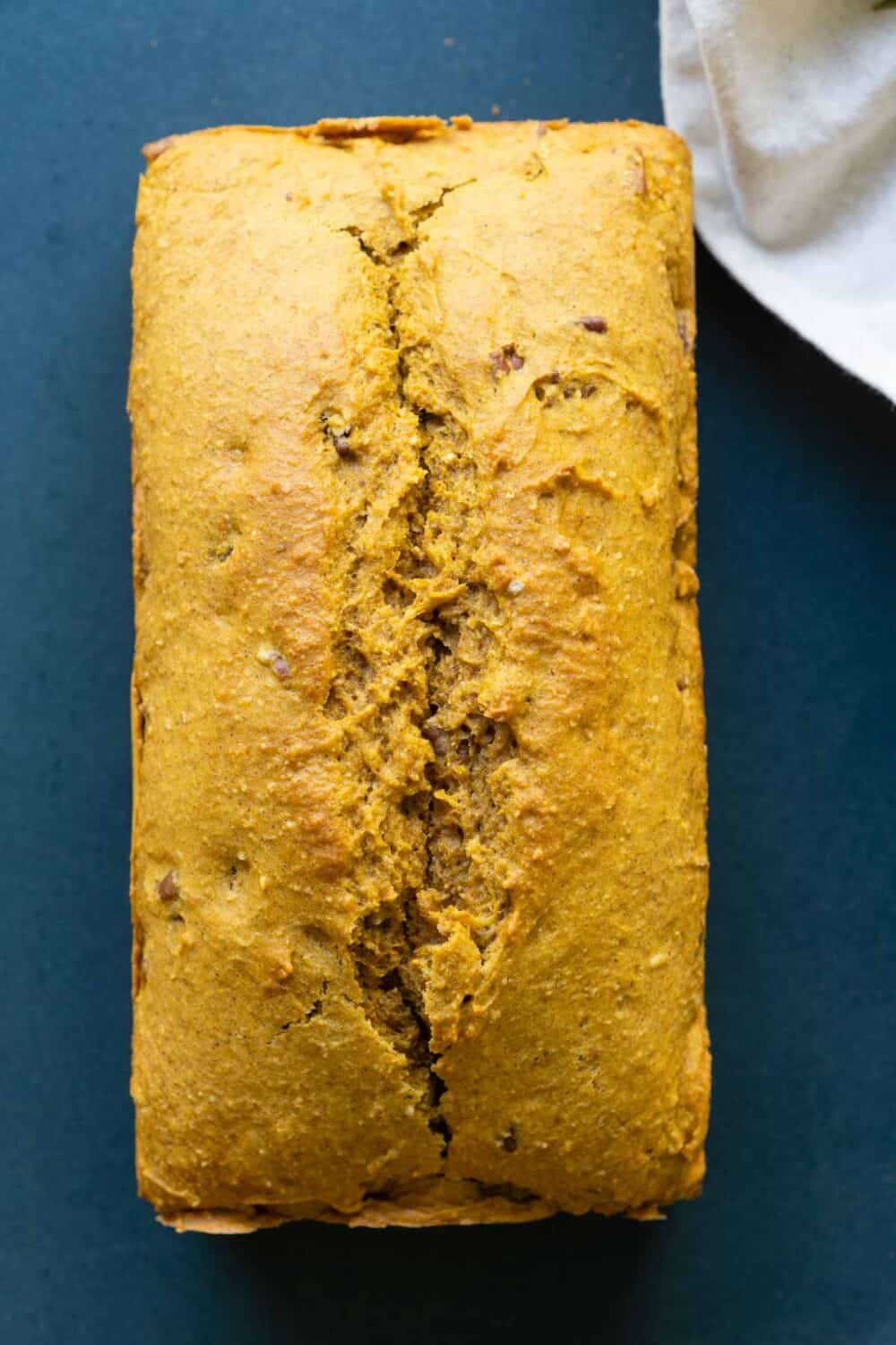 Whole pumpkin bread on a blue plate.