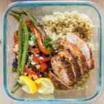 Square bowl with chicken, quinoa, and roasted vegetables.