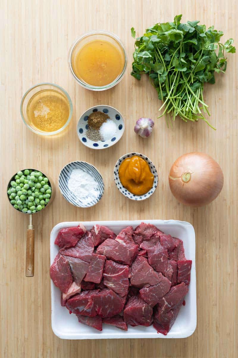 Ingredients for seco de carne beef stew laid out on a kitchen counter.