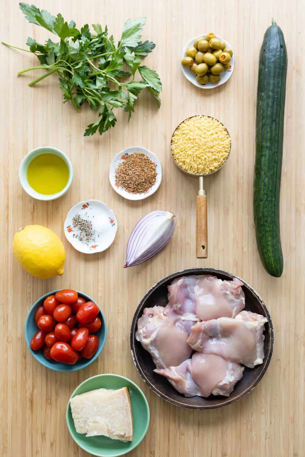 Ingredients to make Mediterranean Chicken Orzo laid out on a kitchen counter.