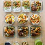 Pin image with text overlay reading 15 healthy meals in one hour and all meals laid out on a kitchen counter.