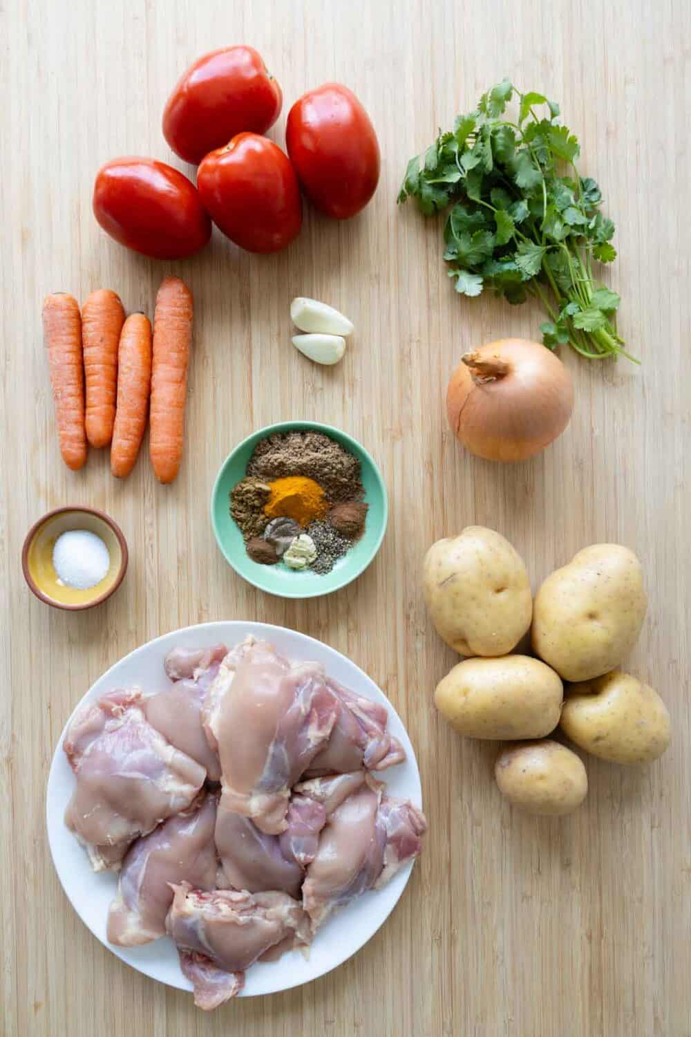 All ingredients necessary to make Mauritian Chicken Curry laid out on a kitchen counter.