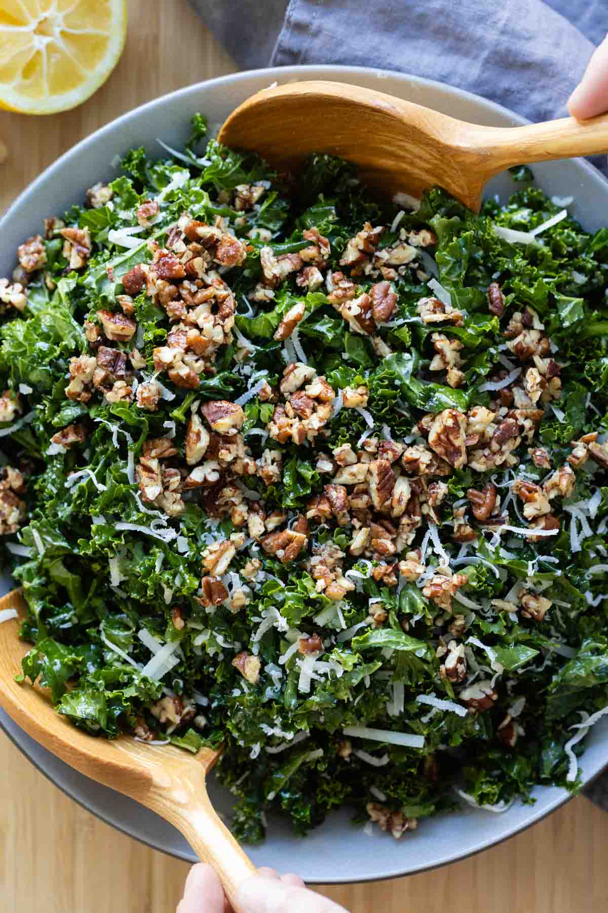 Kale Crunch Salad in a grey salad bowl with wooden spoons.