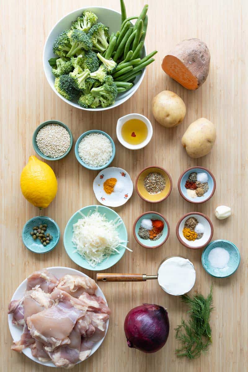 Ingredients for sheet pan chicken meal prep bowls laid out on a kitchen counter.